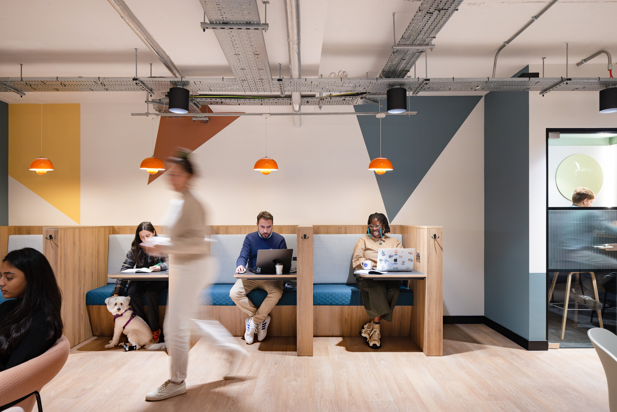 Work.Life Courtyard Building open work booths, with geometric designs and people utilising the space.