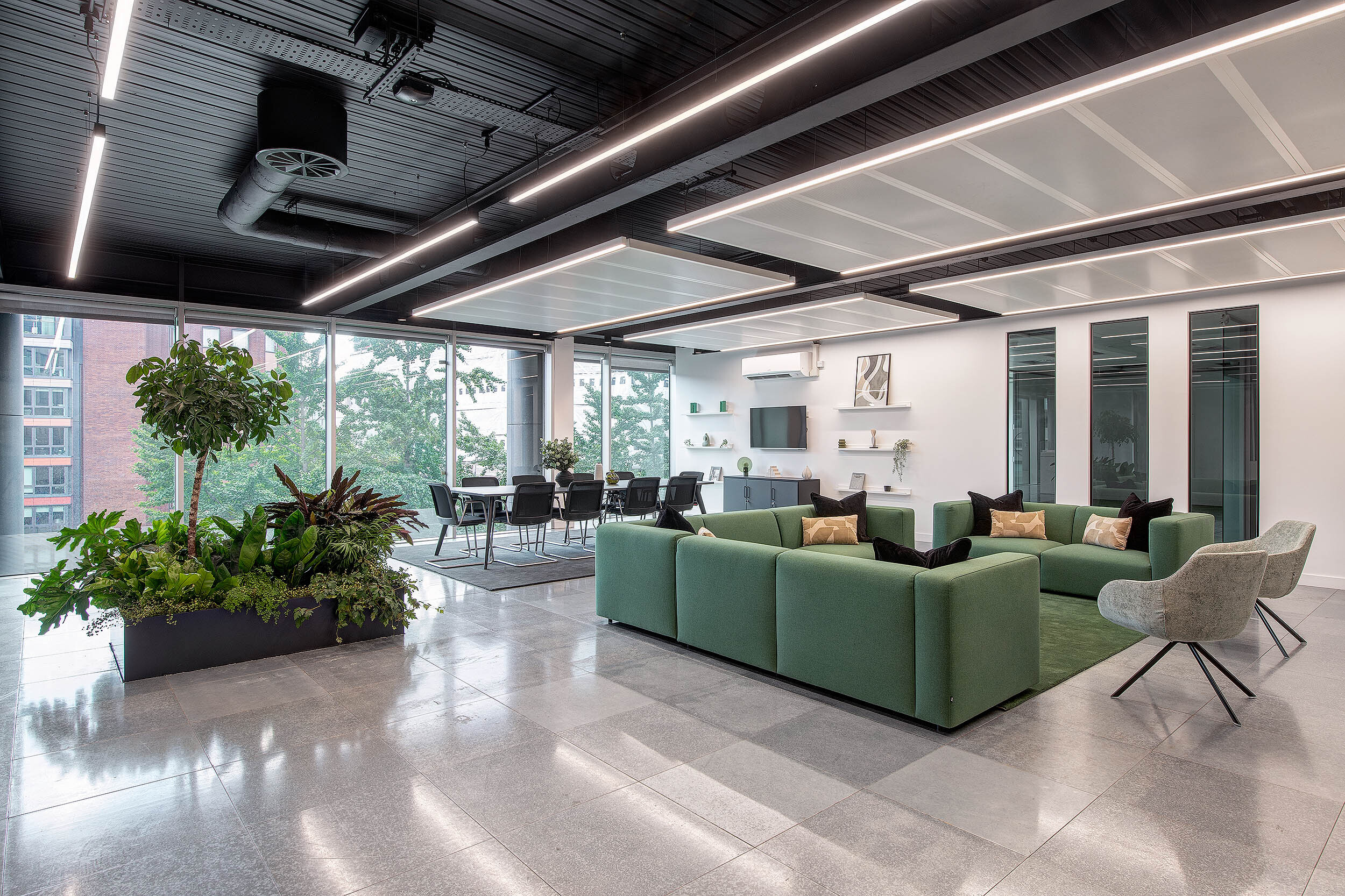 Open-plan marketing office at 95 Queen Victoria Street, featuring biophilic elements, green sofas, and a modern meeting area