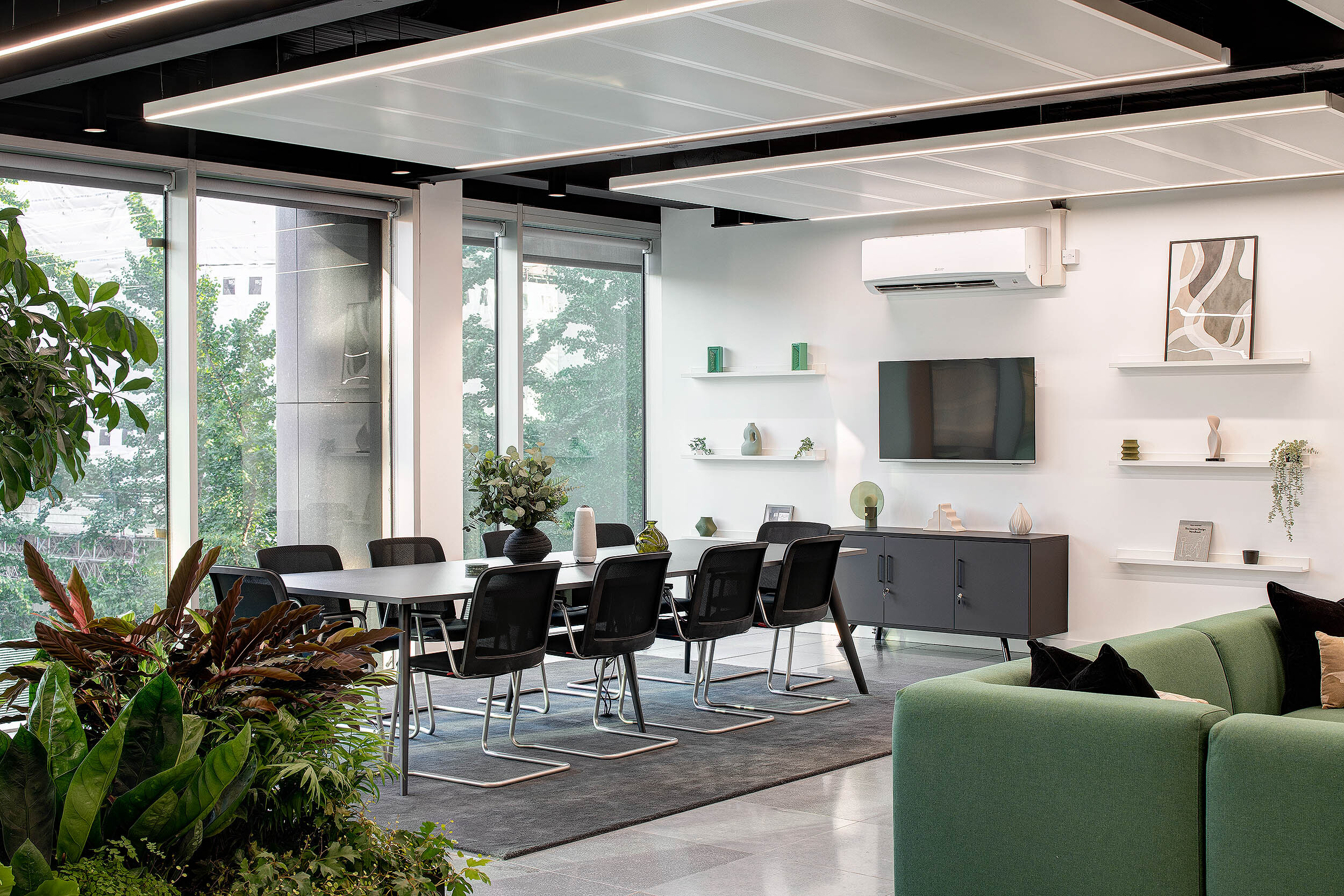 Bright and modern meeting area at 95 Queen Victoria Street designed by Two, featuring a conference table, biophilic accents, and minimalist shelving.