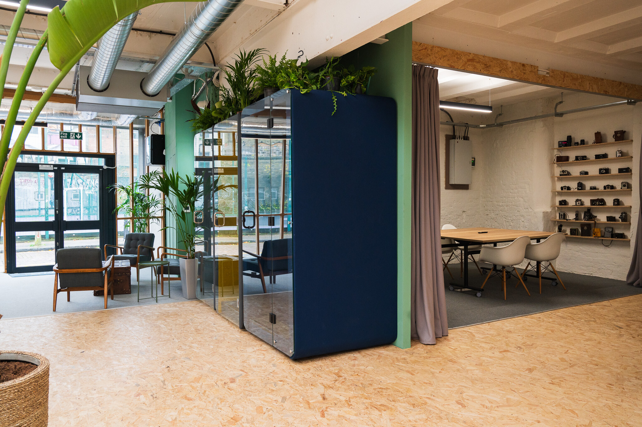 Contemporary office design for FOMO Rentals by Two, featuring a private phone booths and a bespoke camera set-up and meeting room space.