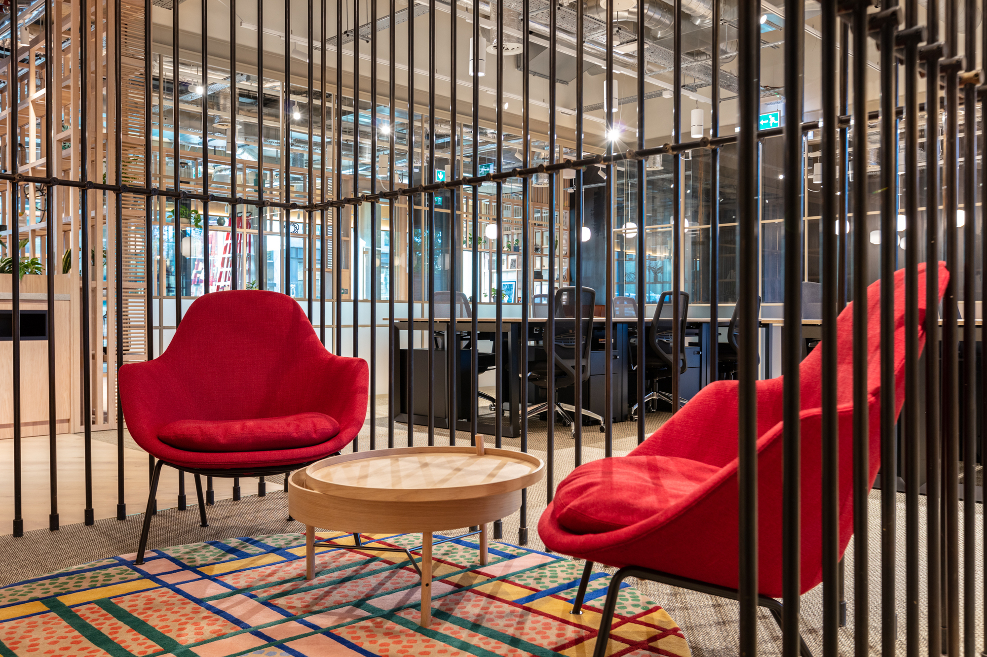Bold red seating and a patterned rug in a private breakout area at FORA Borough Market, designed by Two for a modern coworking office