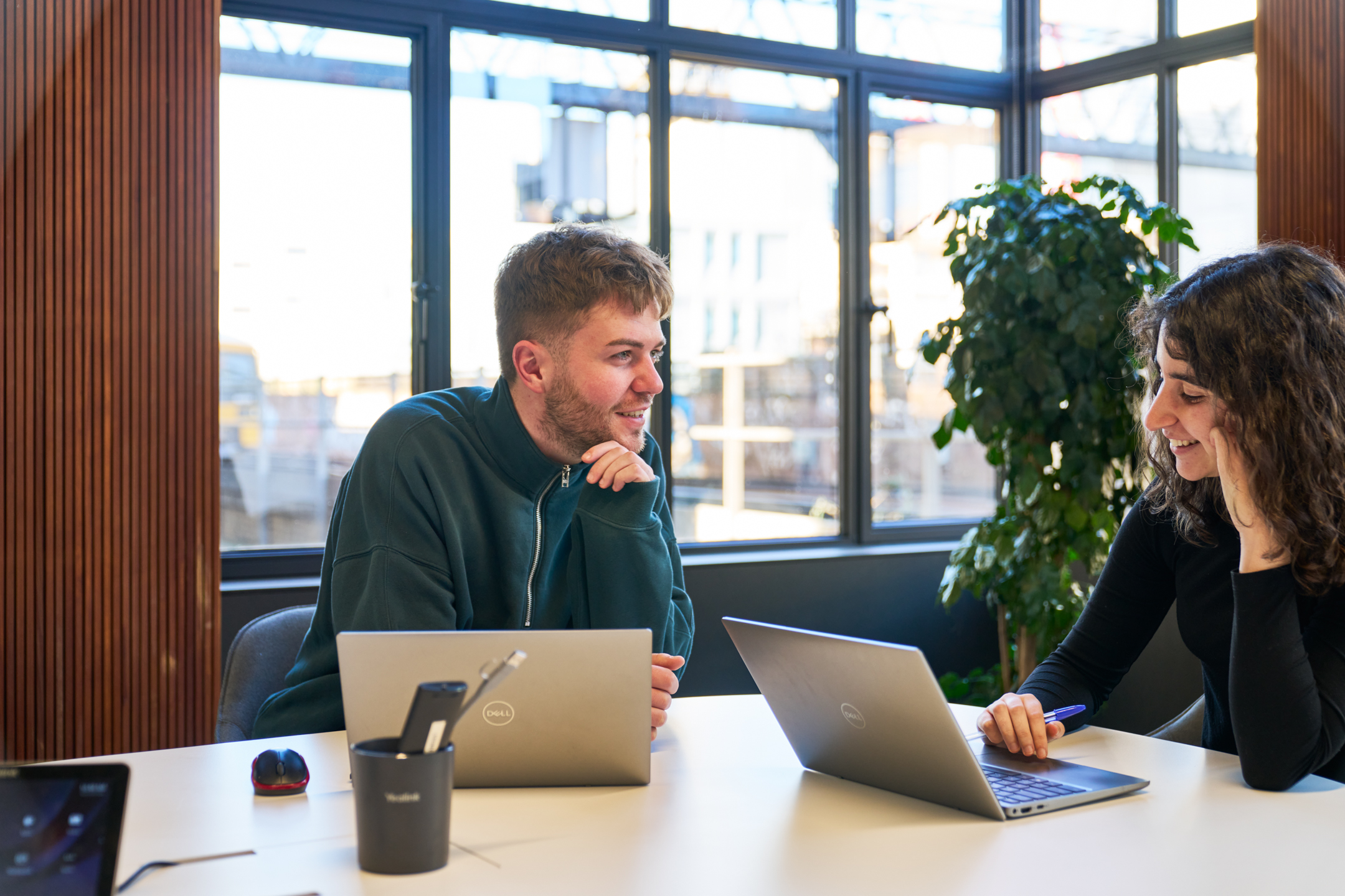 Two colleagues collaborating at a table in the Joseph Joseph office, designed by Two, with natural light streaming through large windows.