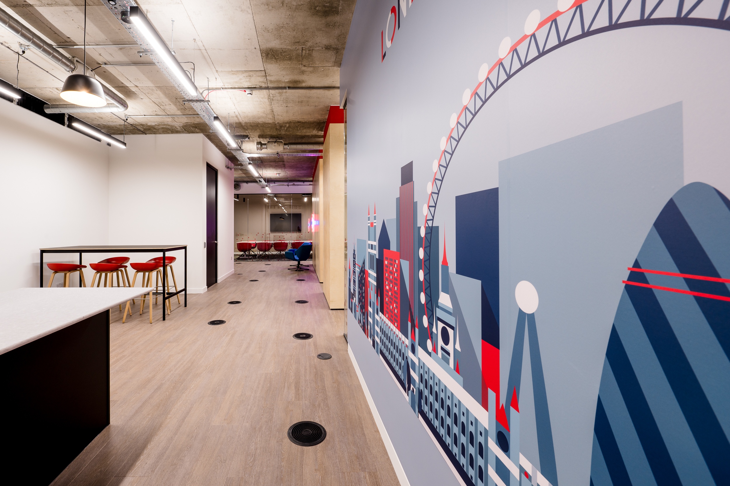 Hallway in the MicroStrategy office, decorated with London-themed wall graphics and leading to versatile meeting spaces.