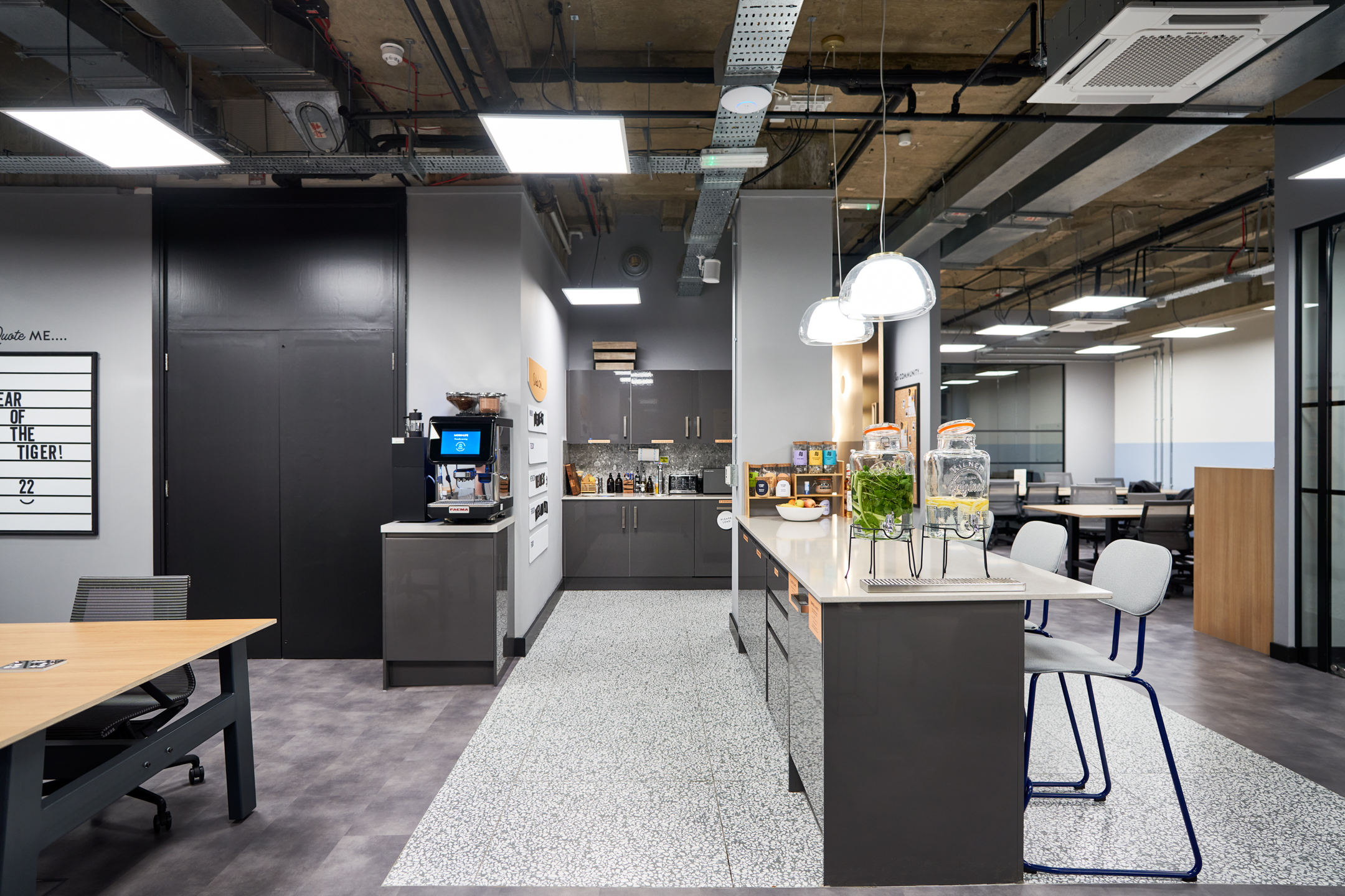 A chic communal kitchen at Work.life Liverpool Street by Two, offering a modern workspace with sleek countertops, hydration stations, and a coffee machine for a refreshing break from work