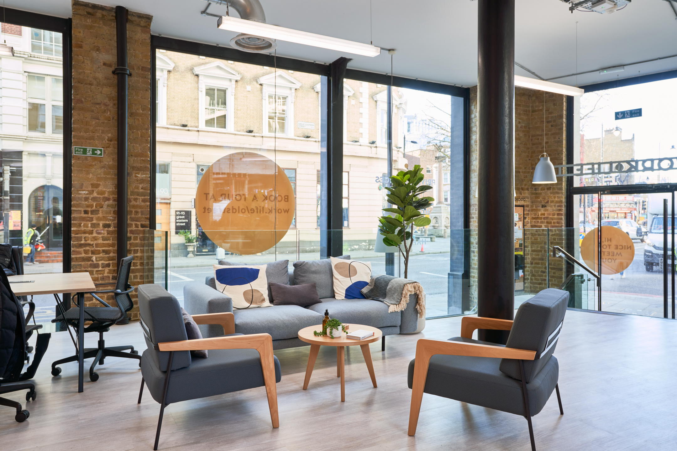A welcoming lounge area at Work.life Rivington House by Two, with modern furniture and large windows allowing natural light to enhance the inviting workspace.