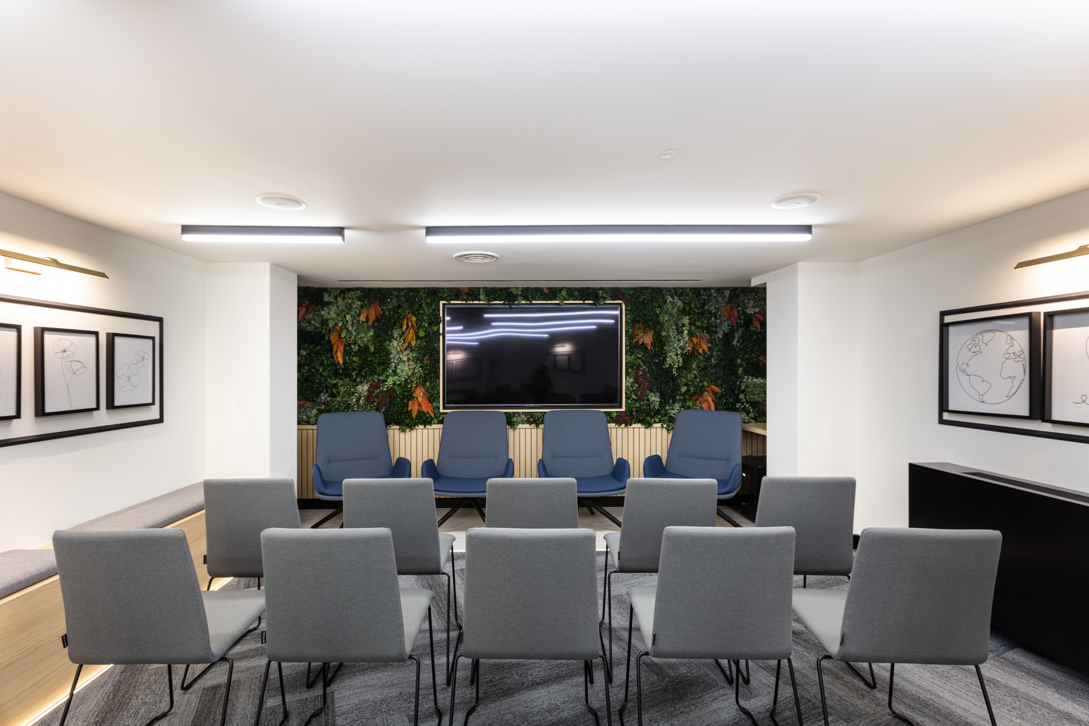 A professional meeting space in Work.life Red Lion Street with contemporary chairs and a lush green feature wall, showcasing Two's innovative approach to creating workspaces.