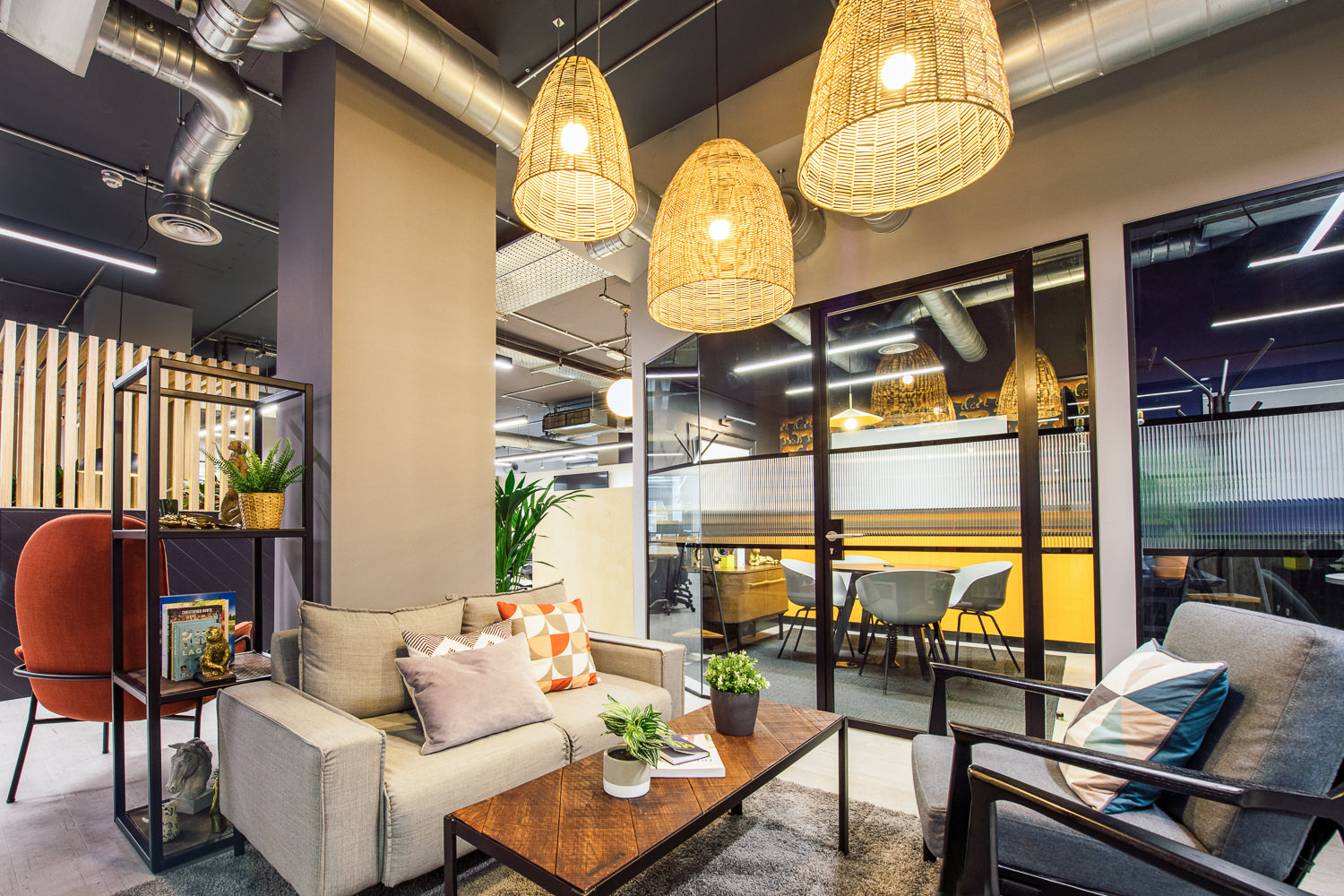A cosy breakout area at Work.life Soho by Two, showcasing modern furniture, rattan lighting, and a warm workspace atmosphere.