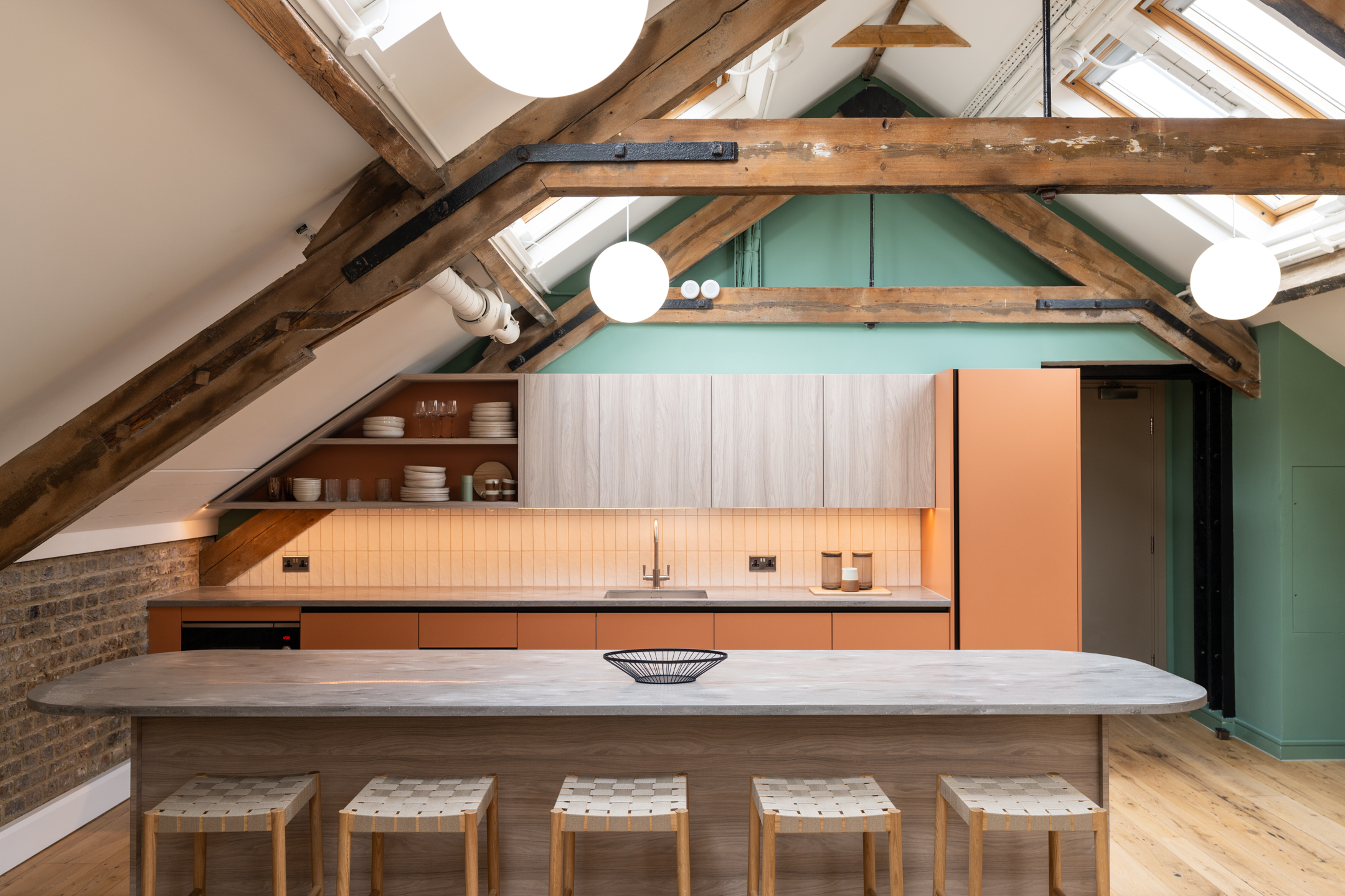 Two The Varnish Works teapoint, featuring a bohemian style layout with attic beams exposed, hanging bespoke lighting and a marble island counter.