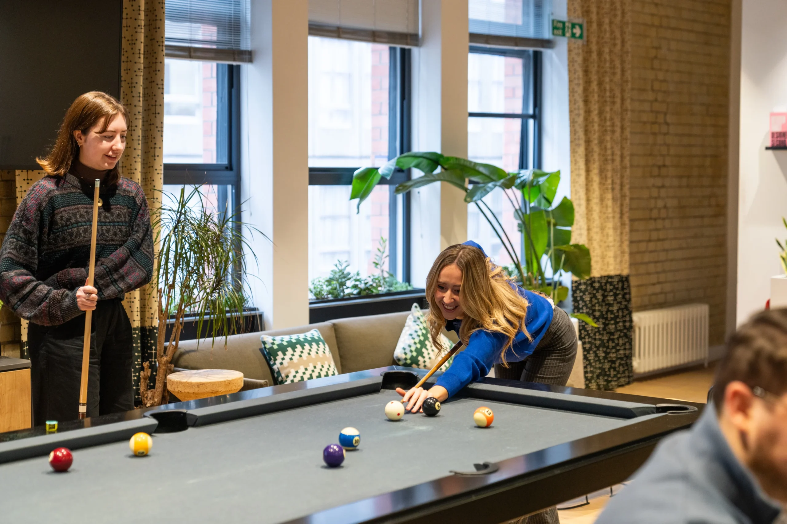 Some employees at Two relax on a break by playing pool in the office