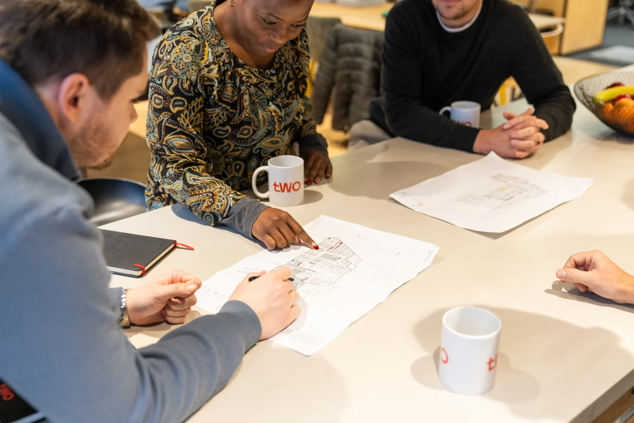 The client services team at Two collaborate around the teapoint in the office